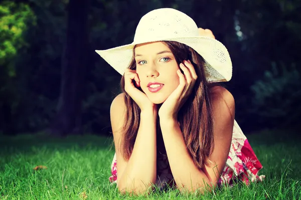 Girl in hat lying on the grass — Stock Photo, Image