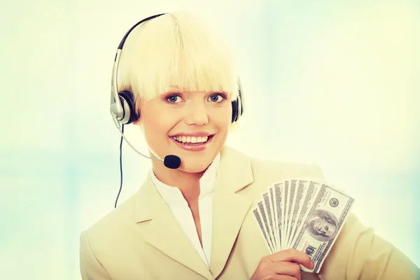 Woman with headset holding dollars — Stock Photo, Image