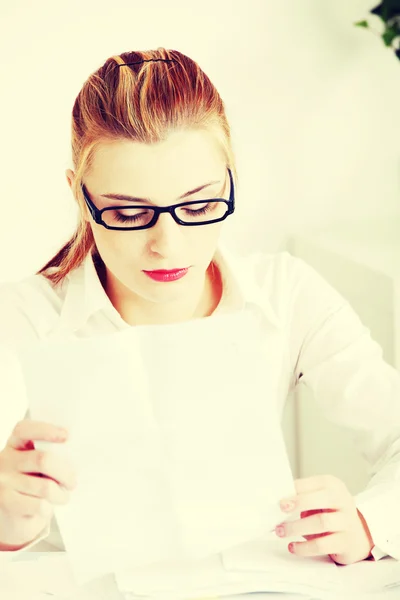 Businesswoman in office reading document — Stock Photo, Image