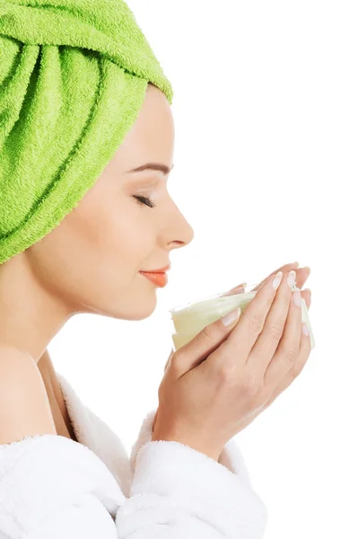 Woman in bathrobe with cream — Stock Photo, Image