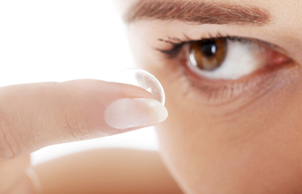 Woman putting contact lens in her eye