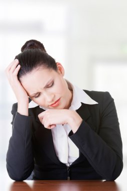 Masanın arkasında oturan üzgün iş kadını.