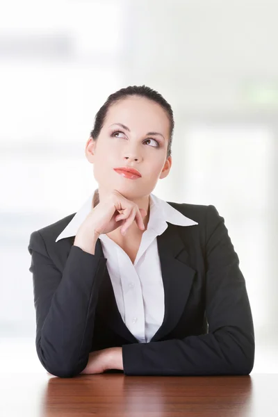 Mujer de negocios bonita sentada en el escritorio y pensando —  Fotos de Stock