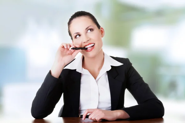 Mujer de negocios bonita sentada en el escritorio y pensando — Foto de Stock