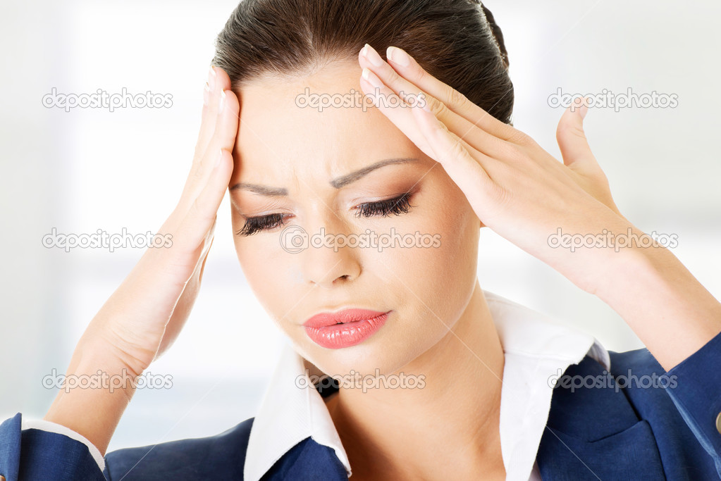 Businesswoman with a headache holding head