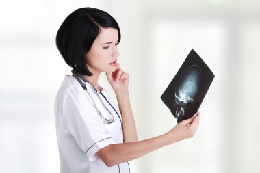 Female doctor or nurse looking at radiography photo clipart