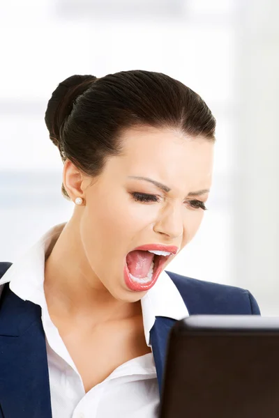 Angry businesswoman shouting on her laptop — Stock Photo, Image