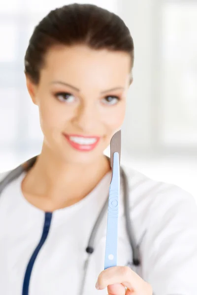 Woman doctor or nurse holding scalpel — Stock Photo, Image