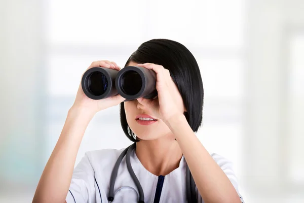 Aantrekkelijke medische meisje op zoek door middel van verrekijkers — Stockfoto