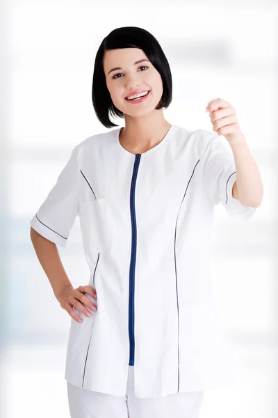 Woman doctor or nurse holding business card — Stock Photo, Image