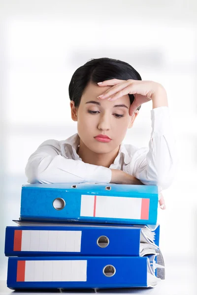 Sad woman with ringbinders sitting at the desk. — Stock Photo, Image