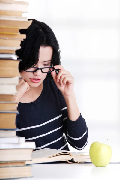 Jonge student vrouw studeren aan de balie — Stockfoto