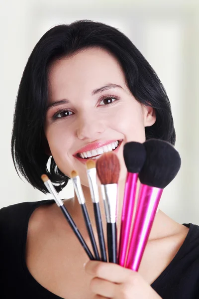 Joven maquilladora mujer sosteniendo cepillos —  Fotos de Stock