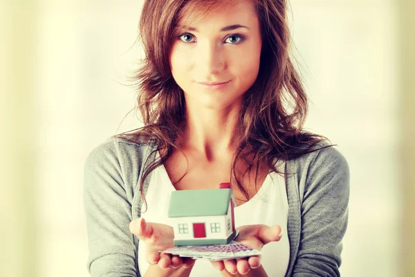 Woman holding euros bills and house model — Stock Photo, Image