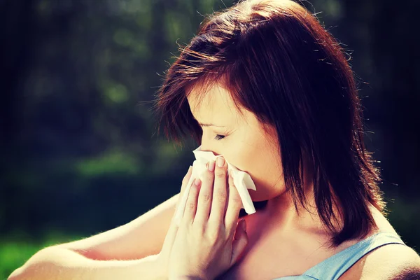 Mujer joven con alergia se limpia la nariz. — Foto de Stock