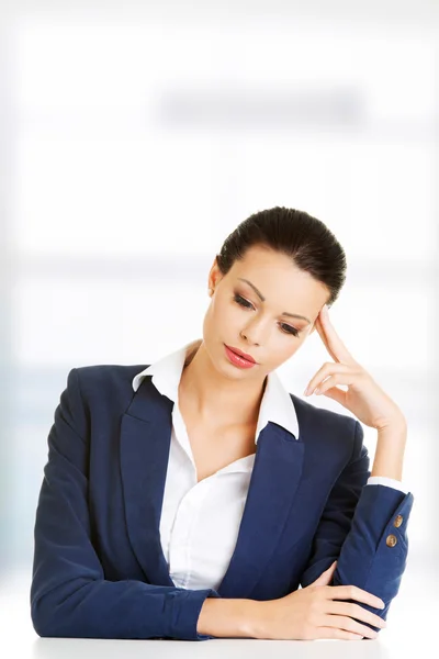 Sad businesswoman sitting behind the desk — Stock Photo, Image