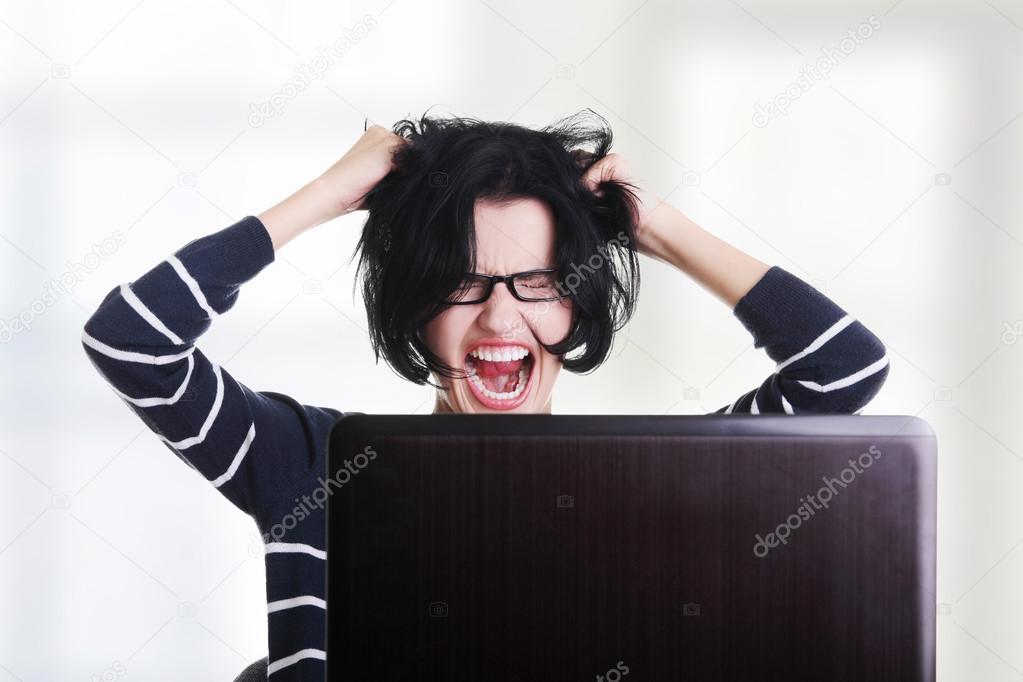 Frustrated woman working on laptop
