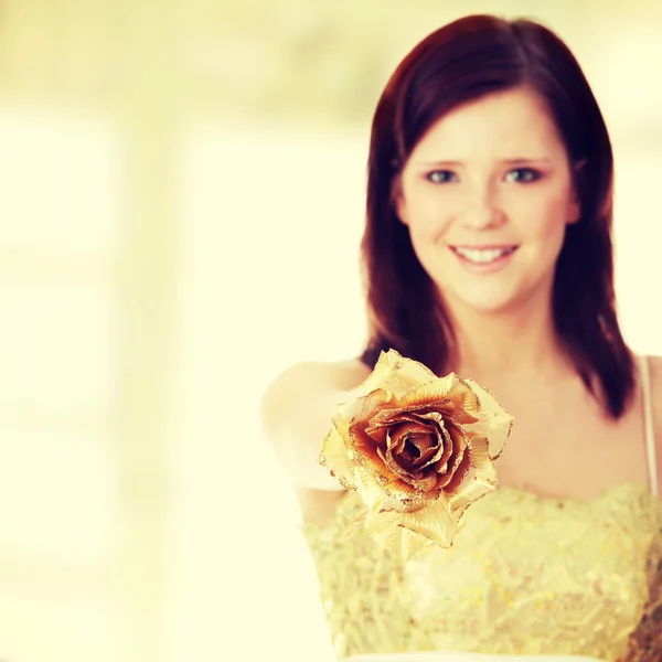 Beautiful woman holding gold rose — Stock Photo, Image