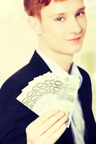 Joven hombre de negocios guapo sosteniendo euros — Foto de Stock