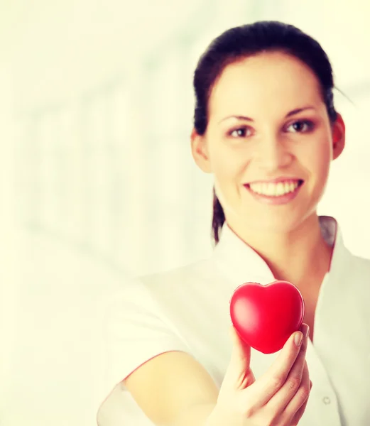 Enfermera joven con el corazón en la mano — Foto de Stock