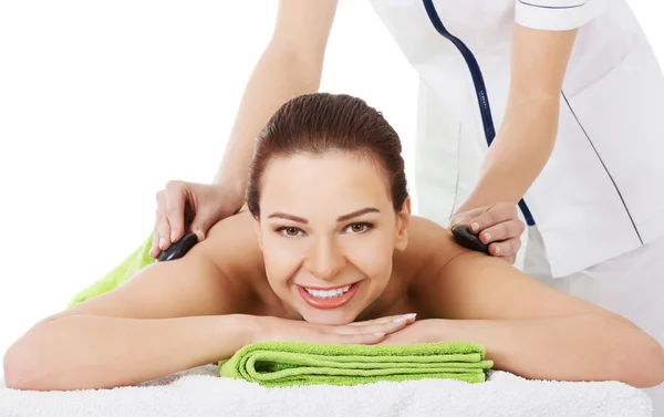 Mooie vrouw op spa salon met stenen massage. — Stockfoto