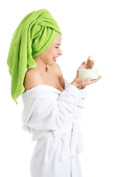 Woman in bathrobe with cream
