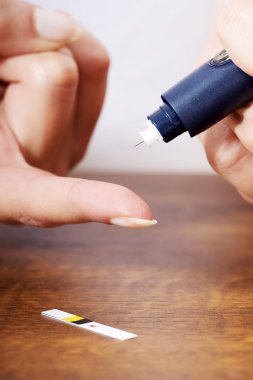 şeker seviyesi testi yapıyor kadın.