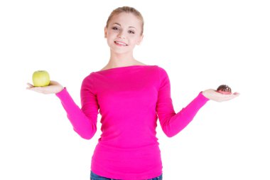 bir elma ve çerez tutan genç casual kadın.