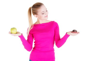 bir elma ve çerez tutan genç casual kadın.