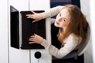 sıcak bir içecek ile oturan ve çalışan kadın