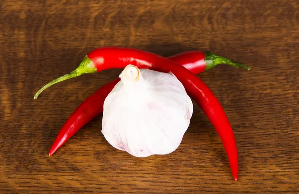 Två chilipeppar liggande med vitlök. — Stockfoto