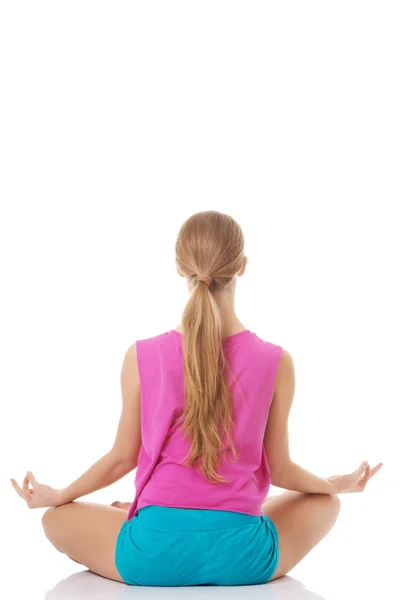 Mulher branca jovem bonita está se exercitando, fazendo ioga . — Fotografia de Stock