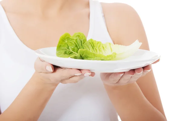 Junge schlanke Frau mit Salat auf einem Teller. — Stockfoto