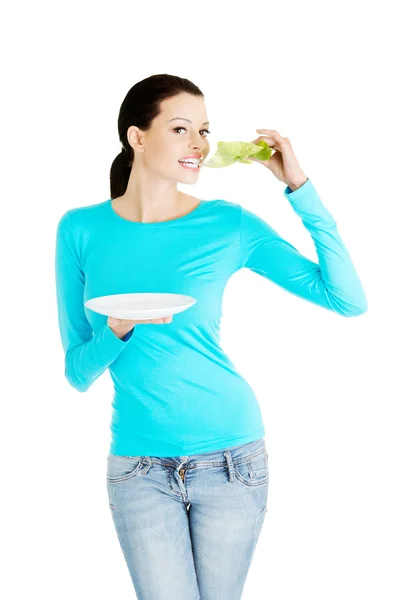 Young beautiful woman eatting lettuce leaf. — Stock Photo, Image