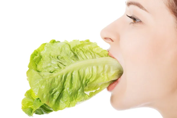 Joven hermosa mujer delgada comiendo lechuga . — Foto de Stock