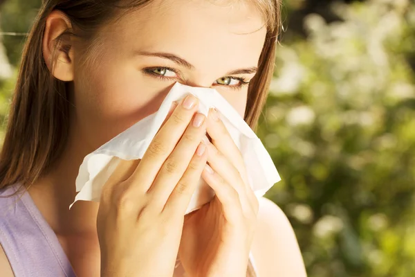 Attractive young woman outdoor with tissue. — Stock Photo, Image