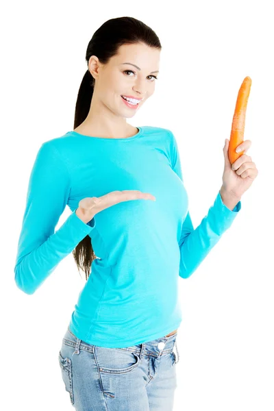 Young beautiful woman holding fresh carrot. — Stock Photo, Image