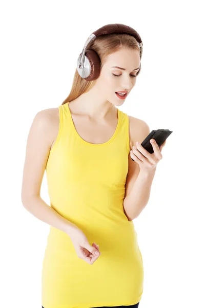 Ung vacker kvinna lyssnar på musik med hörlurar. — Stockfoto