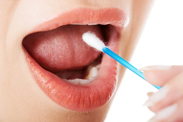 Young woman putting ear stick into mouth. — Stock Photo, Image