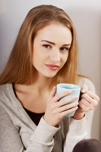 Frau sitzt mit Heißgetränk. — Stockfoto