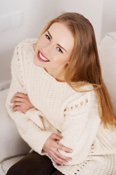 Woman sitting on a couch. — Stock Photo, Image