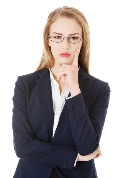 Mujer de negocios en gafas con el dedo en la mejilla . — Foto de Stock