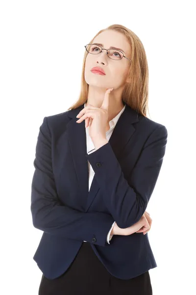 Γυναίκα των επιχειρήσεων σε γυαλιά με το δάχτυλο στο μάγουλό της. — Φωτογραφία Αρχείου