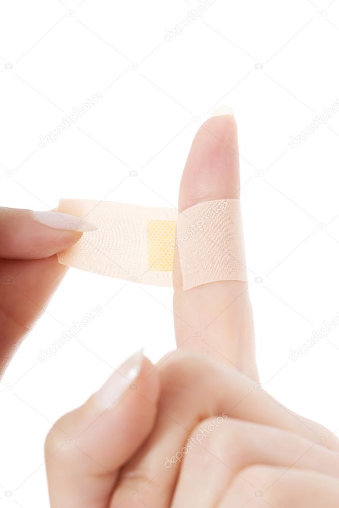 Woman's finger with adhesive tape.
