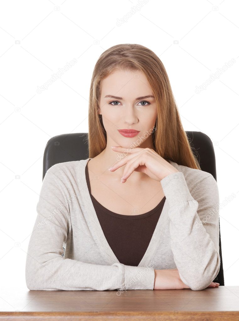 Beautiful casual woman sitting by a desk.
