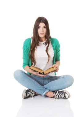 kadın öğrenci oturan ve bir kitap okuma.