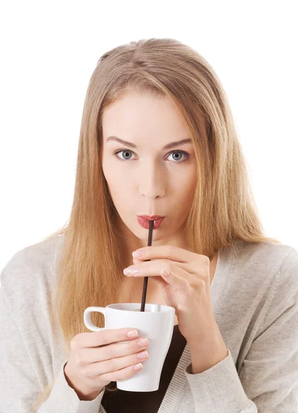 Kobieta pije z filiżanki ze słomy. — Zdjęcie stockowe
