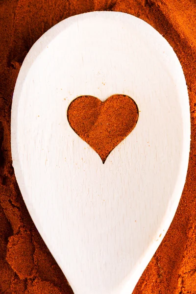 Heart shape made from spice on a wooden spoon. — Stock Photo, Image