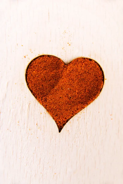 Forma de corazón hecha de especias en una cuchara de madera . — Foto de Stock