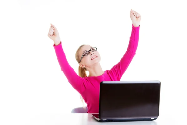 Jeune femme heureuse assise devant un ordinateur portable . — Photo